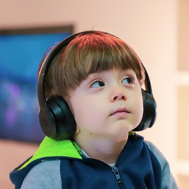 Male child under 5 years old wearing headphones and looking up